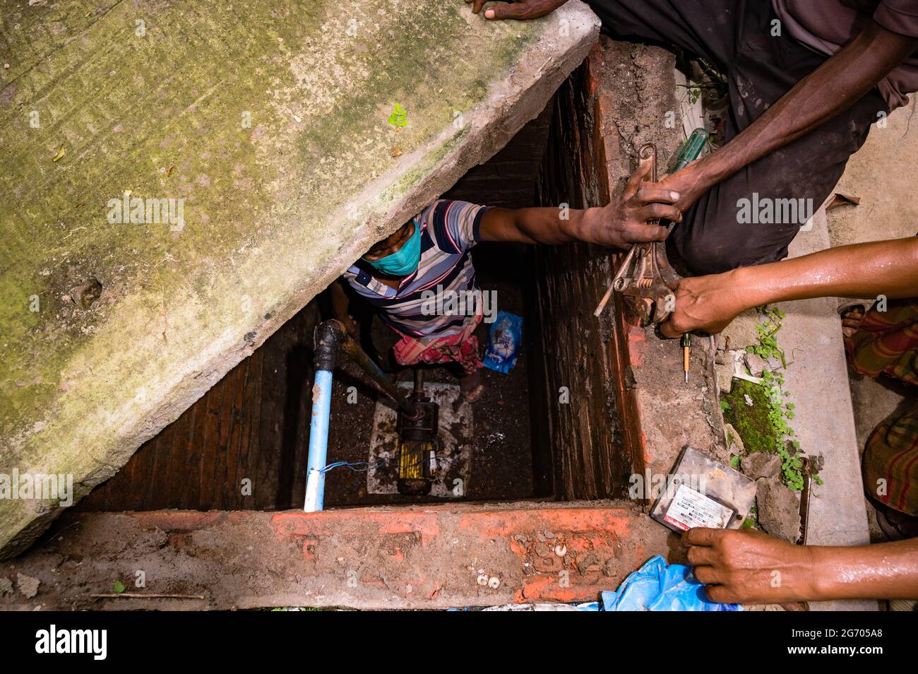 Le gouvernement du Bengale occidental a déclaré que les travaux de construction pourraient reprendre si les entreprises vaccinaient leurs employés et fournissaient un lieu de séjour aux travailleurs. Les mécaniciens réparent une pompe conforme aux règles en vigueur à Tehatta, Bengale-Occidental; Inde. Banque D'Images