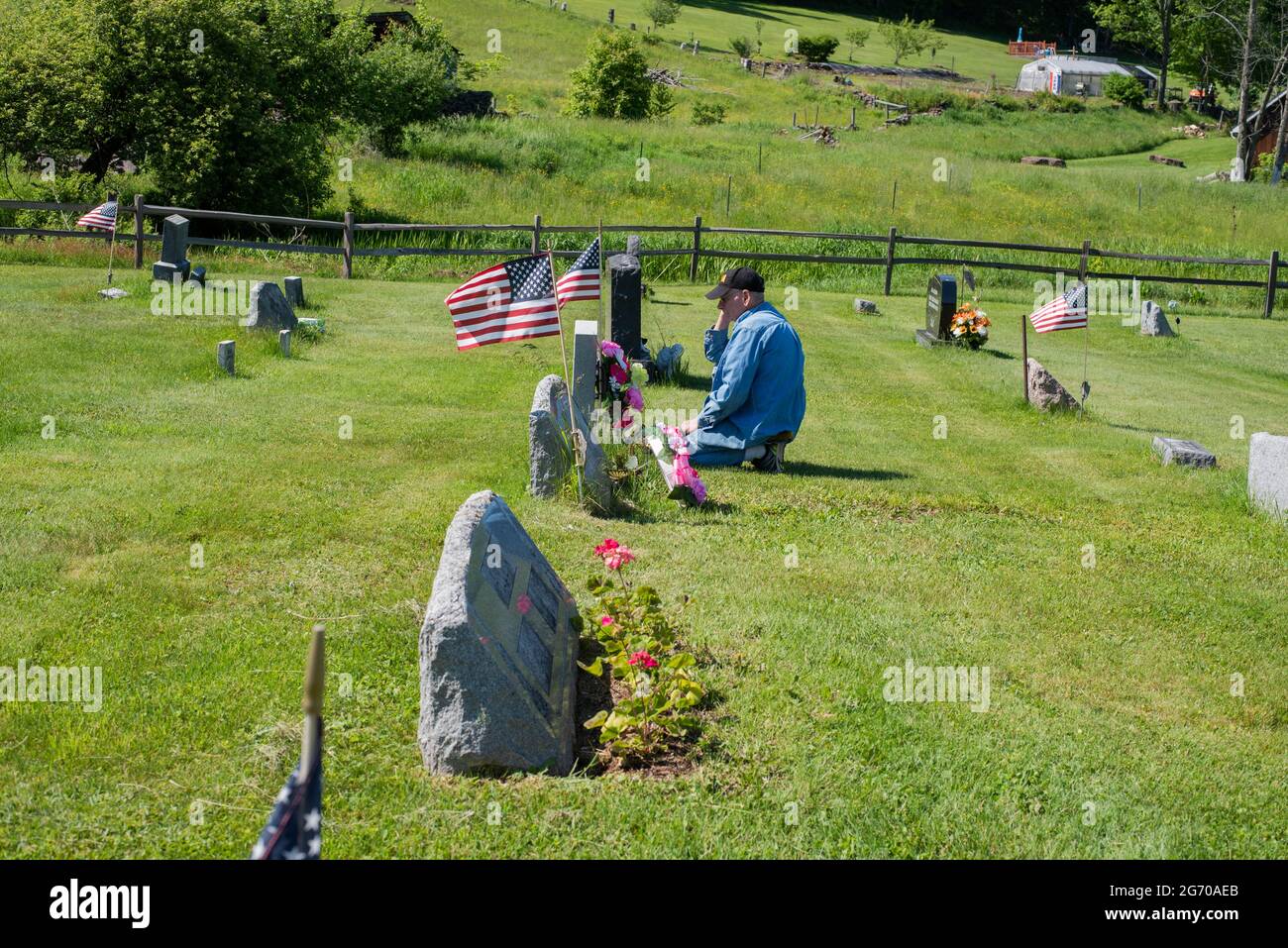 Un homme paie ses respects à un marqueur de sépulture dans un cimetière le jour du souvenir aux États-Unis. Banque D'Images