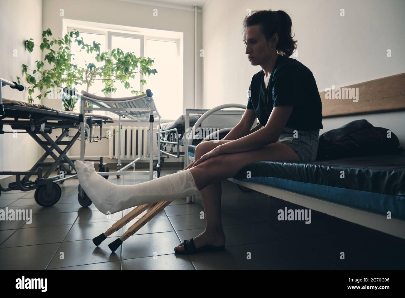 Une femme dont la jambe est cassée est assise sur un canapé d