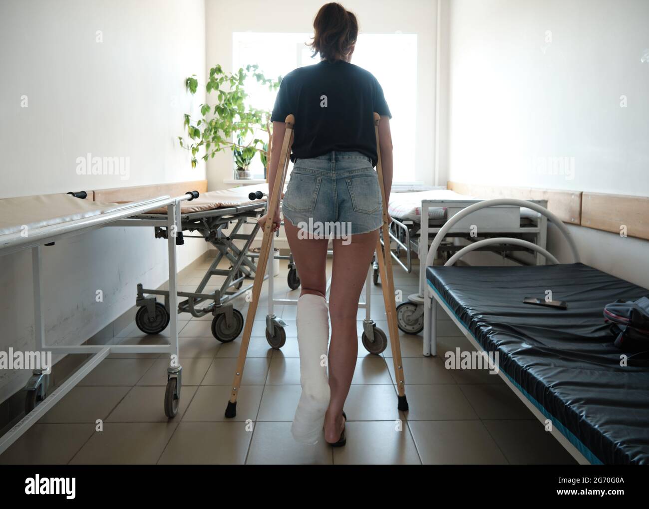 Une femme avec une jambe cassée utilise des béquilles orthopédiques. Blessures aux jambes. Perte