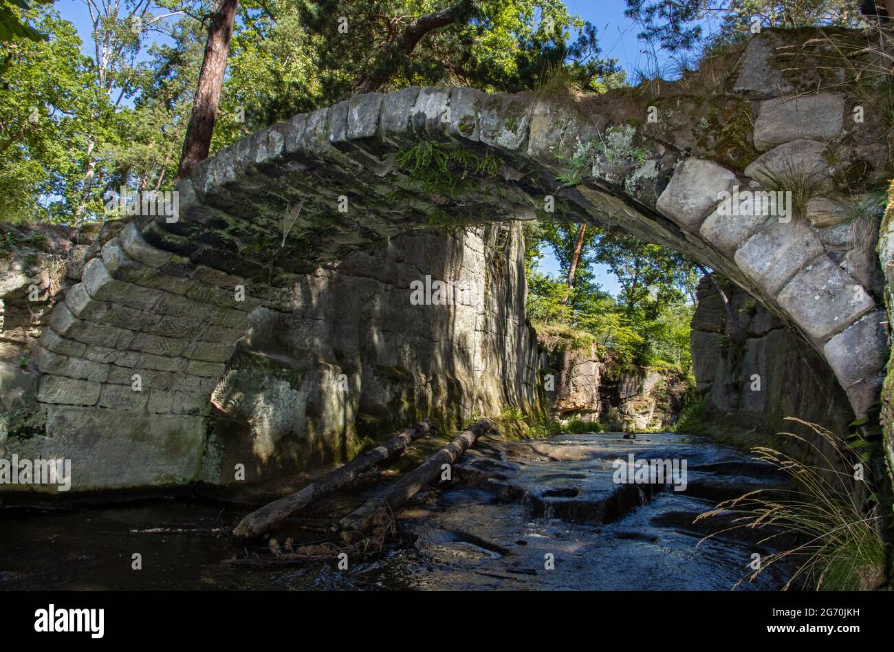 Vieux pont en pierre sur un ruisseau dans les bois Banque D'Images