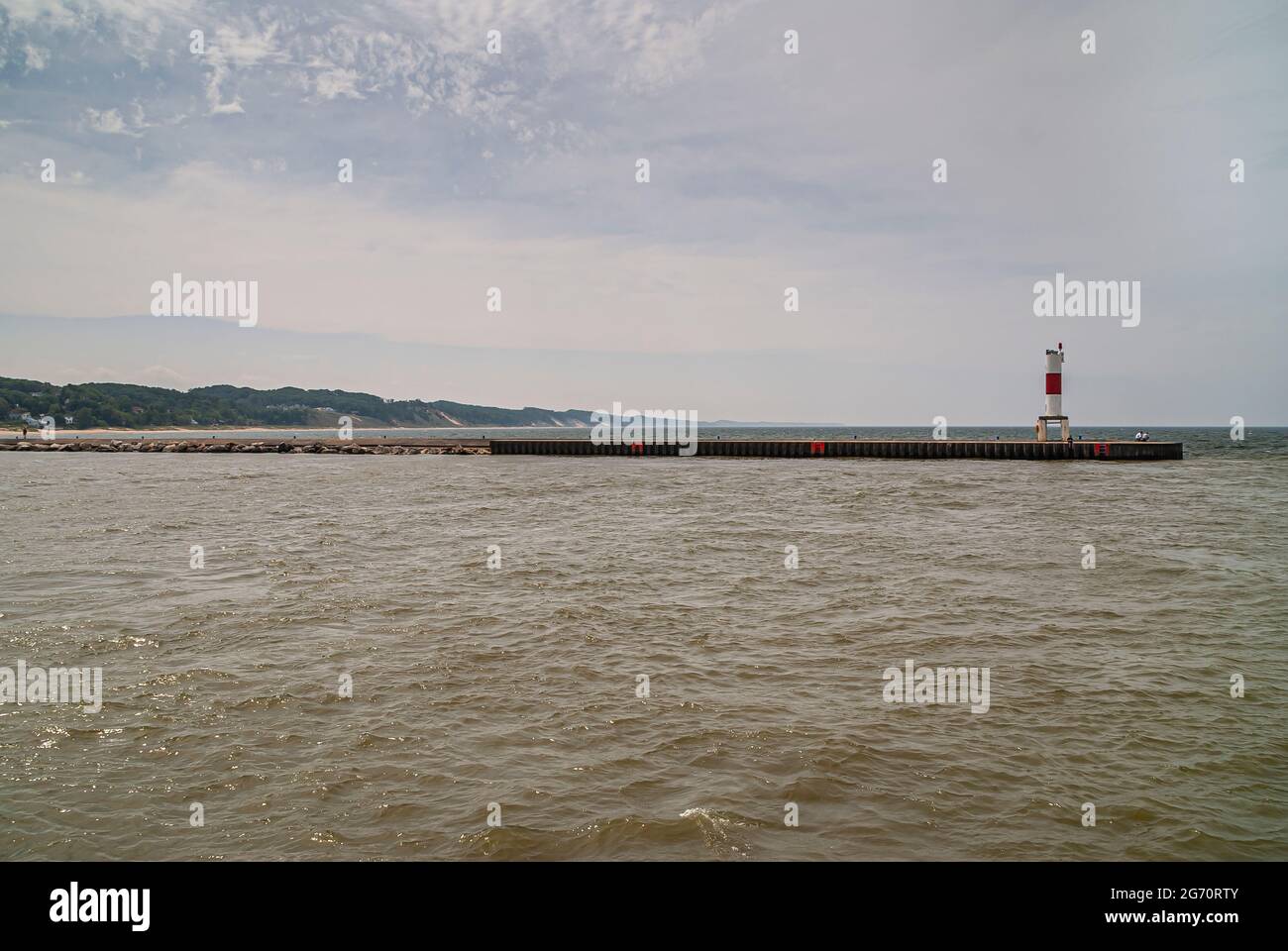 Hollande, MI, États-Unis - 8 juin 2008 : long quai avec balise lumineuse rouge-blanc sépare le lac Macatawa du lac Michigan sous un ciel bleu clair. Foreste Banque D'Images