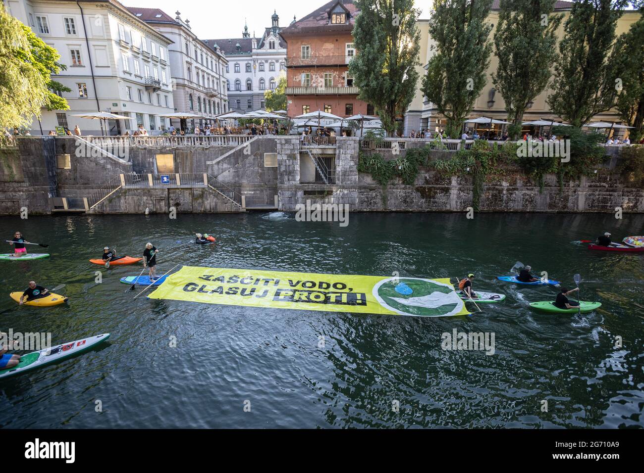 Ljubljana, Slovénie. 09e juillet 2021. Les manifestants sur des planches à pédales, des kayaks et des canoës sur la rivière Ljubljana tirent une grande bannière qui dit "protéger l'eau. Votez non ! » Pendant la manifestation, les manifestations antigouvernementales de vendredi contre les modifications proposées par le gouvernement à la loi sur l'eau ont continué d'encourager le public à voter contre la loi lors d'un référendum qui a lieu le 11 juillet. (Photo de Luka Dakskobler/SOPA Images/Sipa USA) crédit: SIPA USA/Alay Live News Banque D'Images