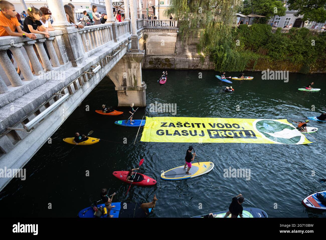 Ljubljana, Slovénie. 09e juillet 2021. Les manifestants sur des planches à pédales, des kayaks et des canoës sur la rivière Ljubljana tirent une grande bannière qui dit "protéger l'eau. Votez non ! » Pendant la manifestation, les manifestations antigouvernementales de vendredi contre les modifications proposées par le gouvernement à la loi sur l'eau ont continué d'encourager le public à voter contre la loi lors d'un référendum qui a lieu le 11 juillet. (Photo de Luka Dakskobler/SOPA Images/Sipa USA) crédit: SIPA USA/Alay Live News Banque D'Images