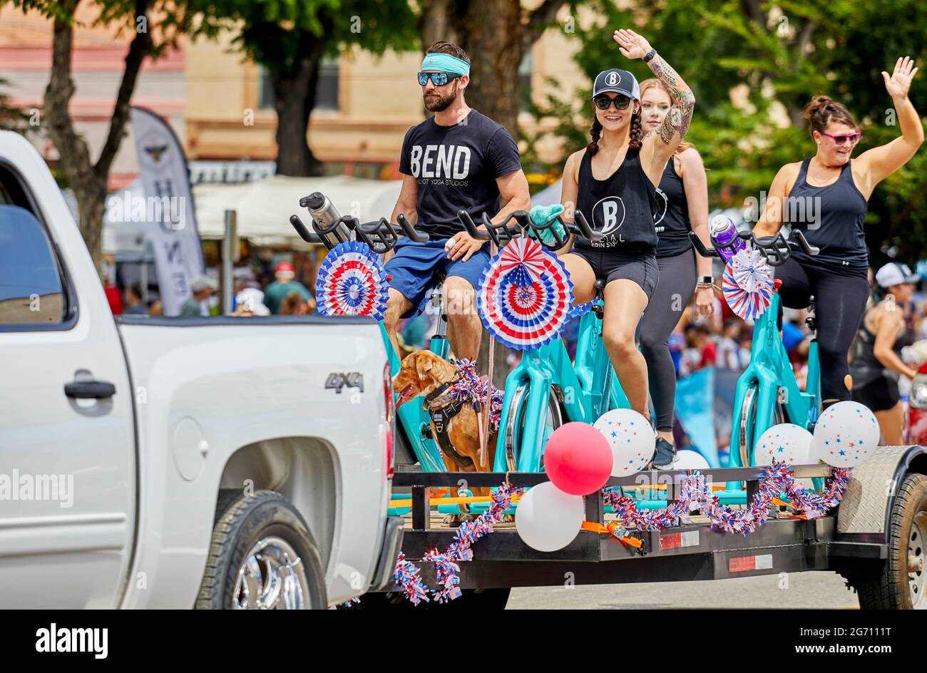 Prescott, Arizona, États-Unis - 3 juillet 2021 : participants à vélo d'appartement et en signe aux spectateurs lors du défilé du 4 juillet Banque D'Images