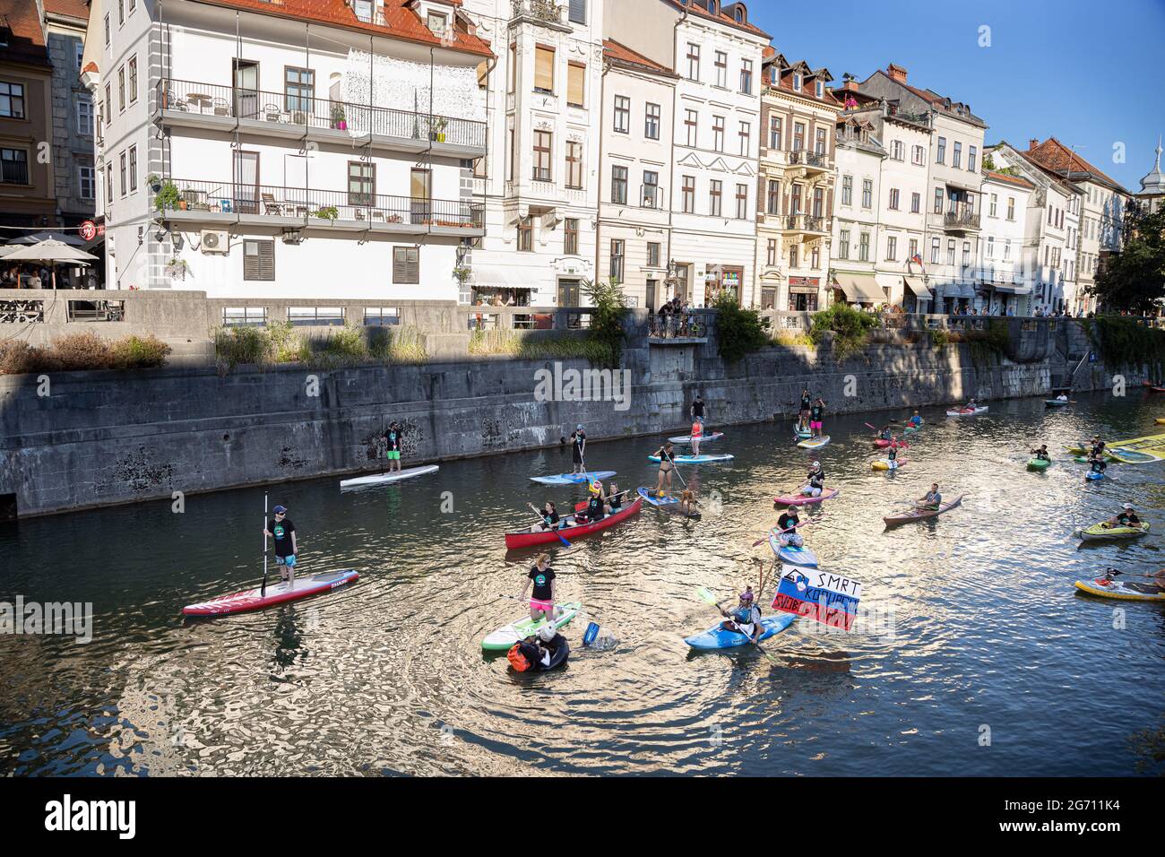 Ljubljana, Slovénie. 09e juillet 2021. Des manifestants sur des planches debout, des kayaks et des canoës sur la rivière Ljujanica, pendant la manifestation.les manifestations antigouvernementales de vendredi contre les modifications proposées par le gouvernement à la loi sur l'eau ont continué d'encourager le public à voter contre la loi lors d'un référendum qui a eu lieu le 11 juillet. Crédit : SOPA Images Limited/Alamy Live News Banque D'Images