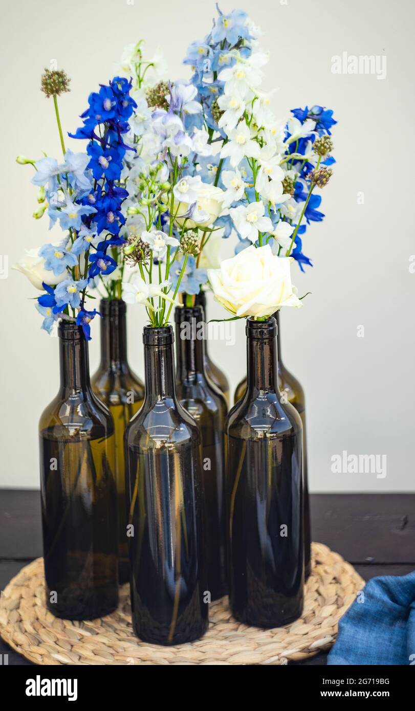 Composition florale d'été fraîche dans des bouteilles de vin sur fond de  béton Photo Stock - Alamy