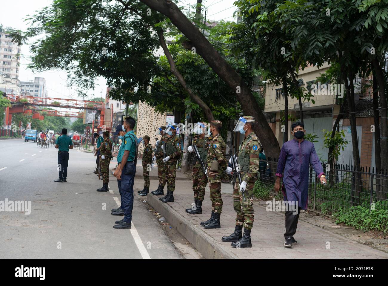 Dhaka, Bangladesh. 10 juillet 2021. Les officiers de l'armée et de la police se tiennent à un poste de contrôle pendant qu'ils vérifient les passagers lors d'un verrouillage. Le gouvernement du Bangladesh a prolongé son verrouillage strict par des ordonnances de séjour à domicile pour les citoyens jusqu'au 14 juillet, alors que le nombre quotidien de décès par coronavirus atteignait un niveau record. Banque D'Images