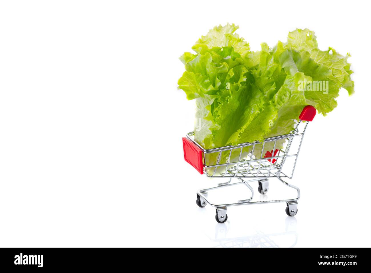 Mini voiture de supermarché isolée sur un fond blanc. Concept de shopping de nourriture saine. Copier l'espace Banque D'Images