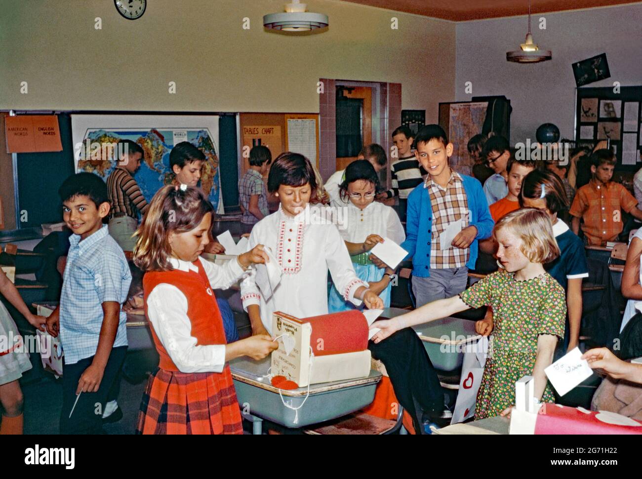 L'éducation en Amérique dans les années 1960 – à l'école primaire Annie Kellond, East Lehigh Drive, Tucson, Arizona, États-Unis en 1969. Ici, les élèves affichent les cartes de Saint-Valentin dans leur salle de classe. Notez les coeurs rouges sur leurs vêtements et attachés aux bureaux. La boîte postale a été adaptée à partir d'une ancienne boîte à chaussures. Aux Etats-Unis, la Saint-Valentin (14 février) est devenue un grand événement dans les écoles. Cette image provient d'une ancienne transparence couleur amateur Kodak américaine, une photographie vintage des années 1960. Banque D'Images