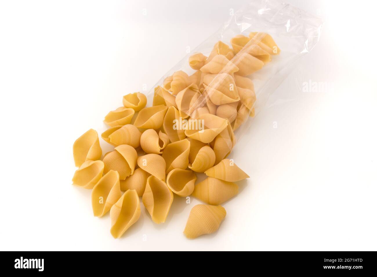 Conchiglioni macaroni pâtes italiennes crues de bronze tiré, de Gragnano, Naples, Italie, en emballage transparent sur fond blanc, espace de copie Banque D'Images