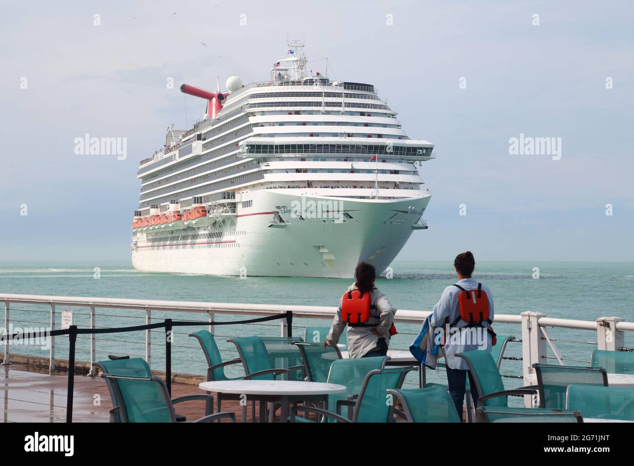 Deux jeunes femmes regardent le bateau de croisière Carnival Magic arriver à Key West, Floride, États-Unis Banque D'Images