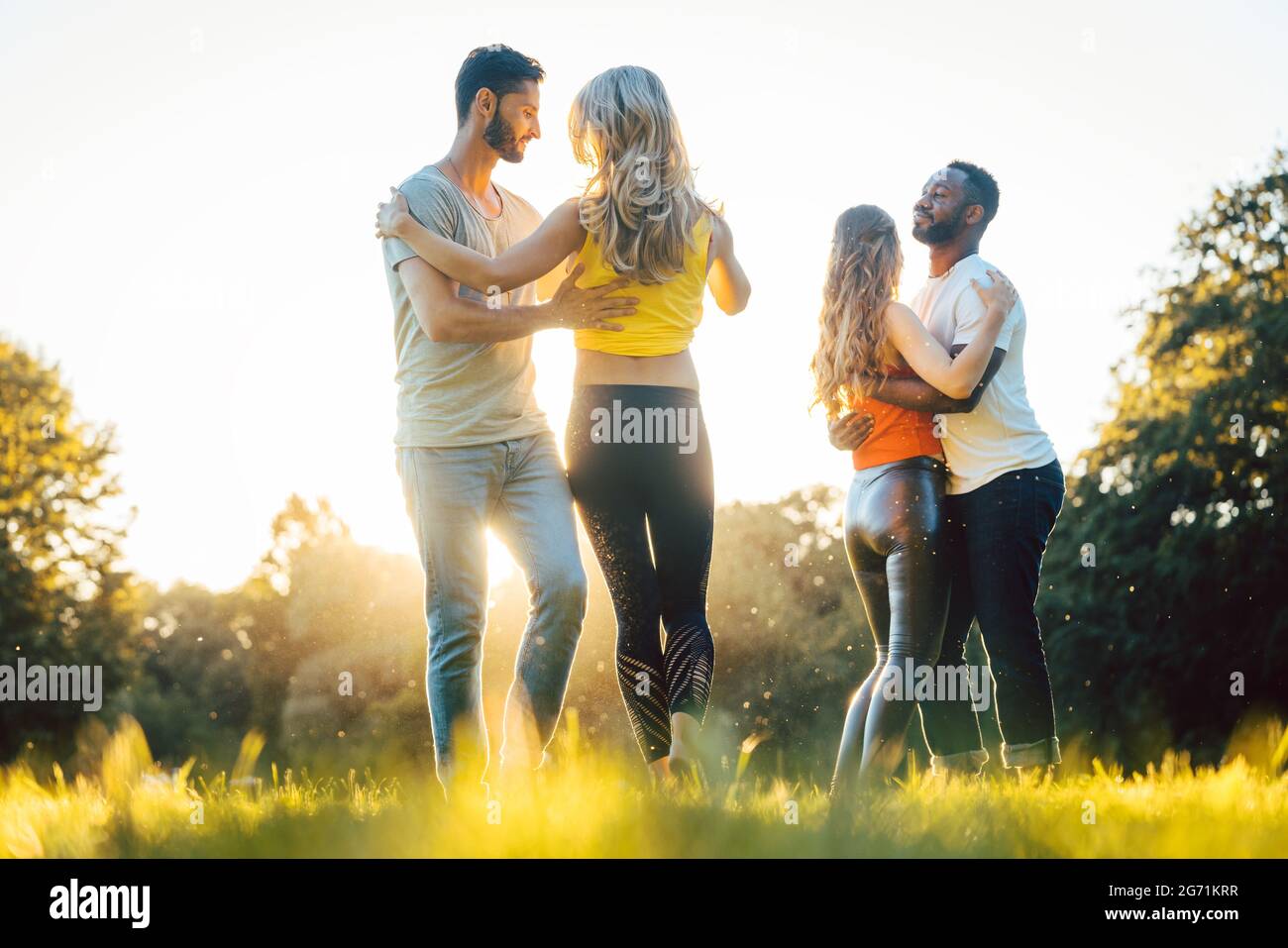 Les femmes et les hommes ayant du plaisir de danser dans le parc comme des couples Banque D'Images