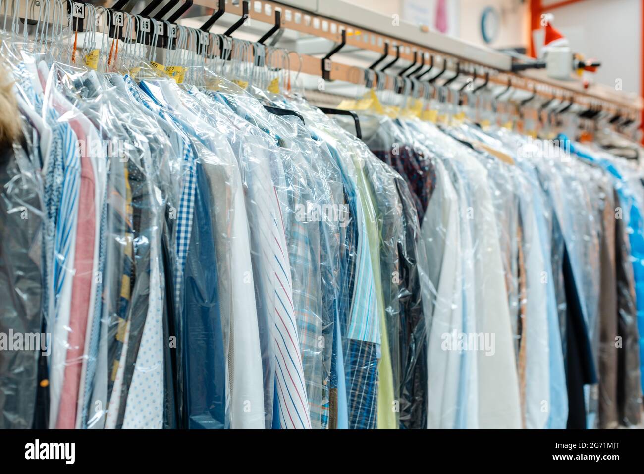 Carousel de vêtements en attente de prise en charge par leurs propriétaires dans un service de nettoyage à sec boutique Banque D'Images