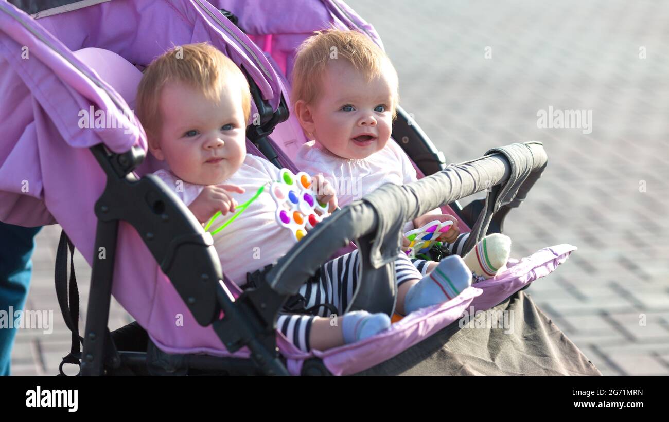 Souriante De Filles Jumelles Dans Une Poussette De Bebe Avec Des Jouets Lumineux Dans Leur Main Photo Stock Alamy