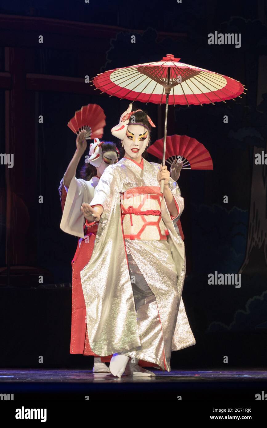 Les femmes japonaises dans les kimono traditionnels dansing avec parapluie et fans. Performances japonaises traditionnelles. Banque D'Images