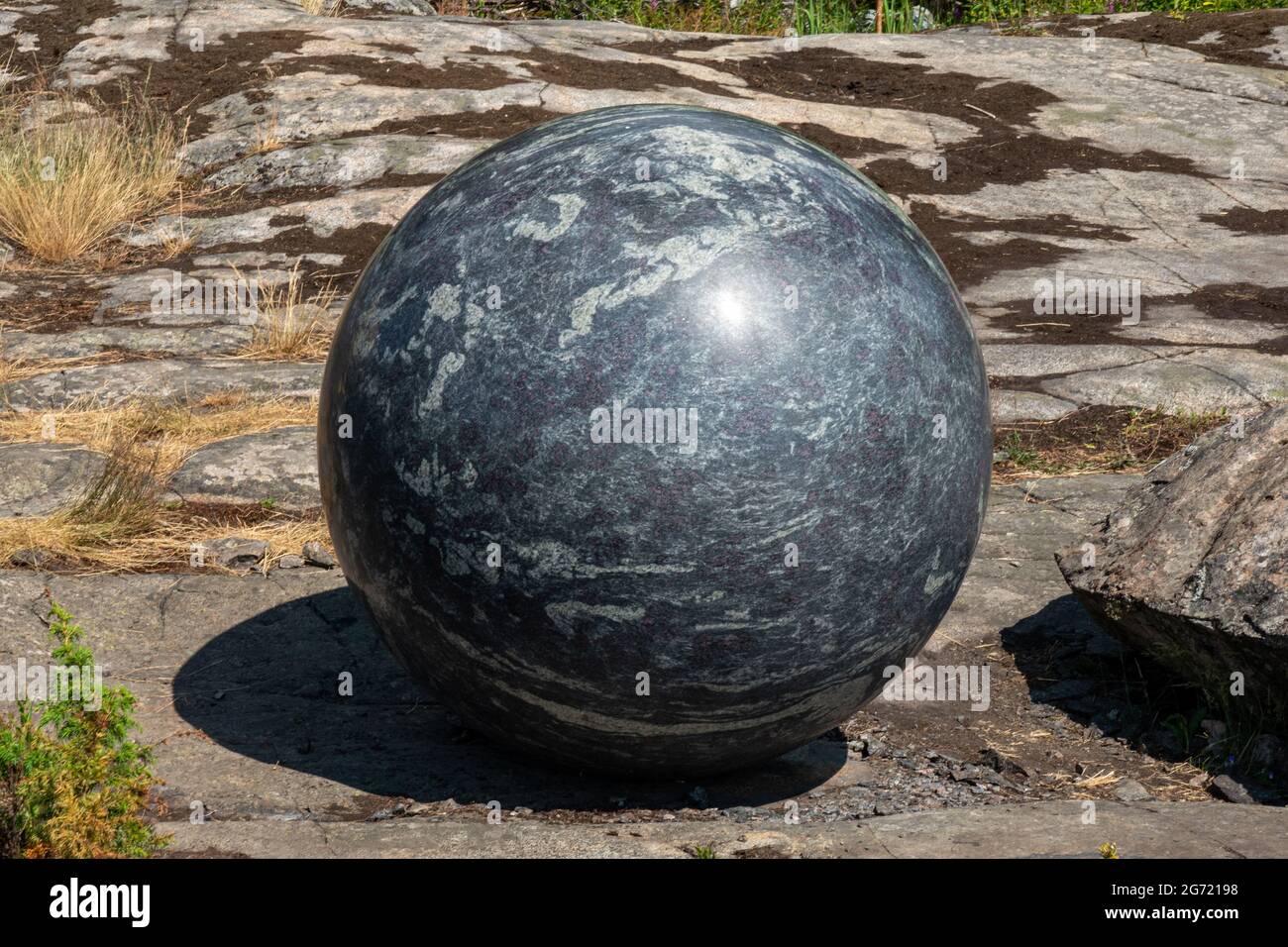 Grand globe en pierre, faisant partie de la sculpture Pars Pro Toto par Alica Kwade, lors de la biennale d'art 2021 d'Helsinki, sur l'île de Vallisaari, en Finlande Banque D'Images