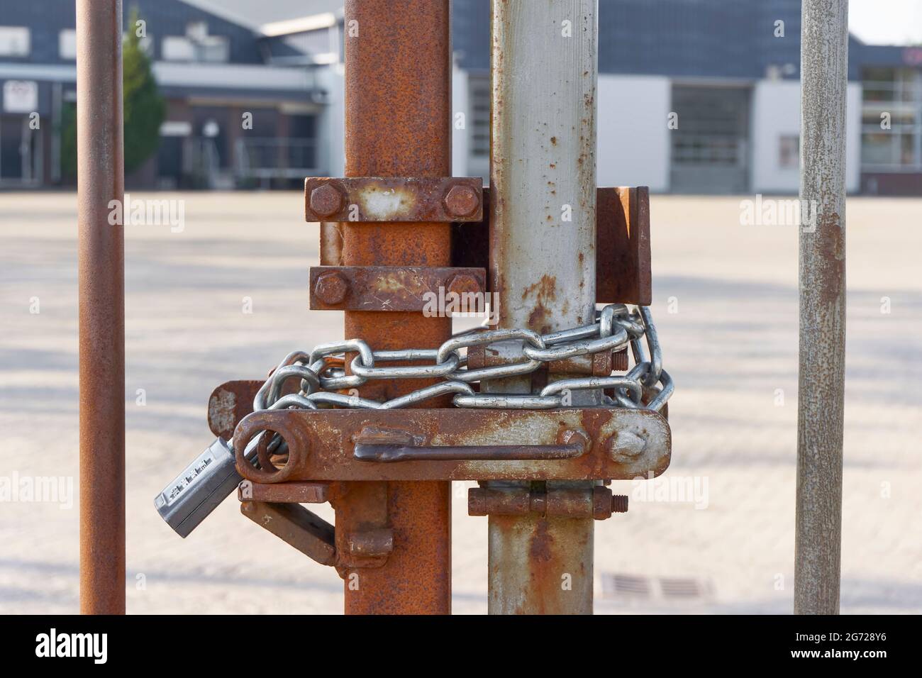 Clôture en métal rouillé verrouillée avec chaîne et cadenas. Immigration aux frontières fermées ou concept de verrouillage. Image avec mise au point sélective. Banque D'Images