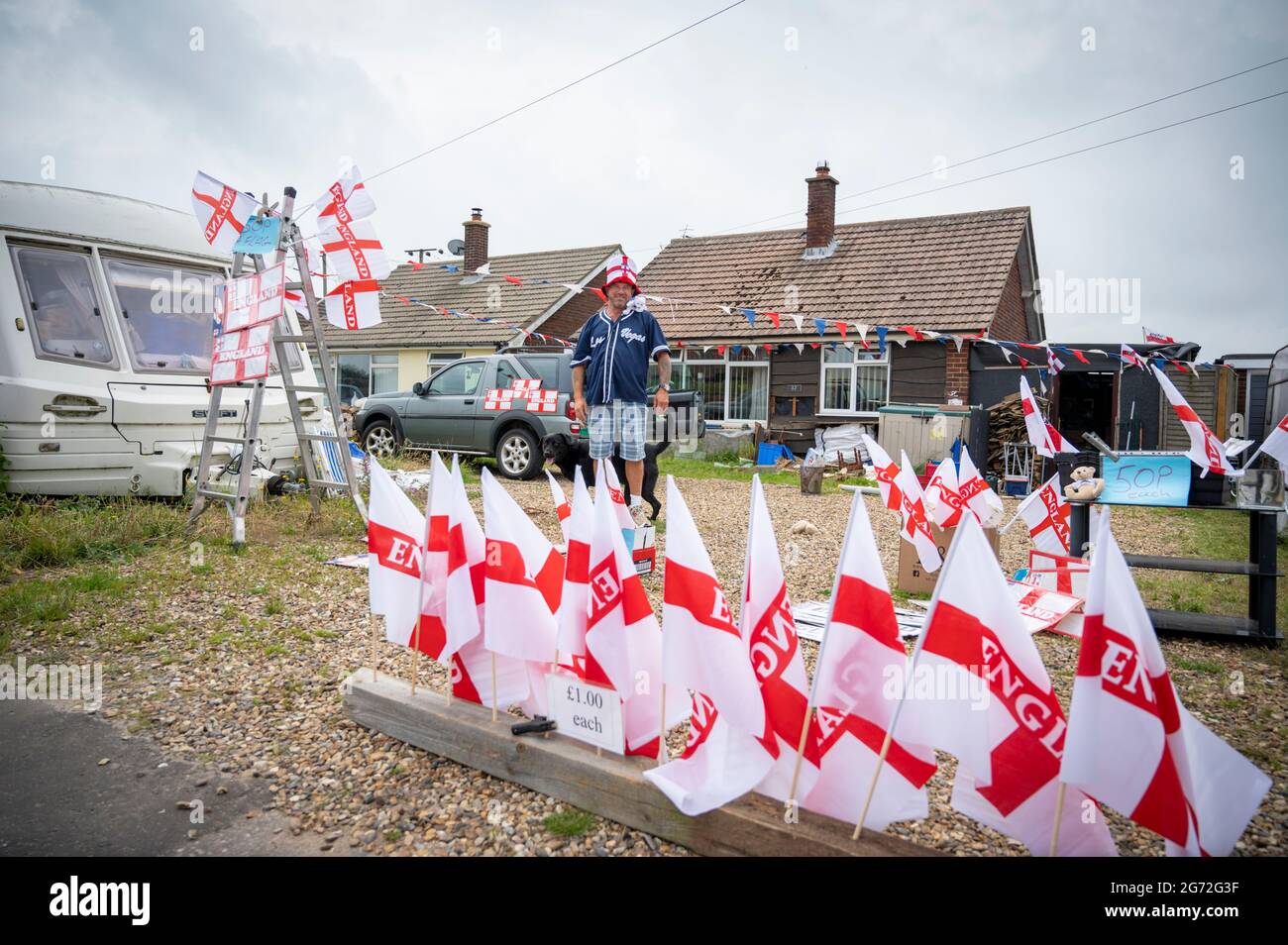 Trimingham, North Norfolk, Royaume-Uni. 10 juillet 2021. Un homme vend des drapeaux de football d'Angleterre, des chapeaux, des enseignes et d'autres souvenirs de supporters depuis son allée devant la finale des championnats d'Europe de football d'Angleterre V Italie à Wembley. Crédit : Julian Eales/Alay Live News Banque D'Images