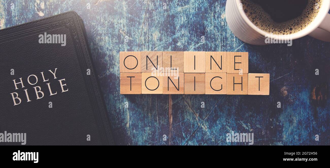 En ligne ce soir écrit en bloc lettres sur une table en bois bleu avec une Bible noire Banque D'Images