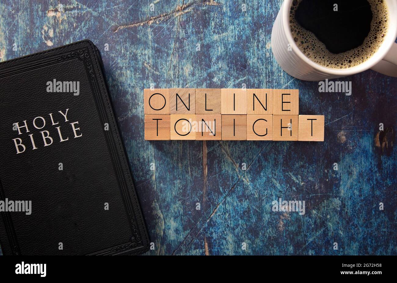 En ligne ce soir écrit en bloc lettres sur une table en bois bleu avec une Bible noire Banque D'Images