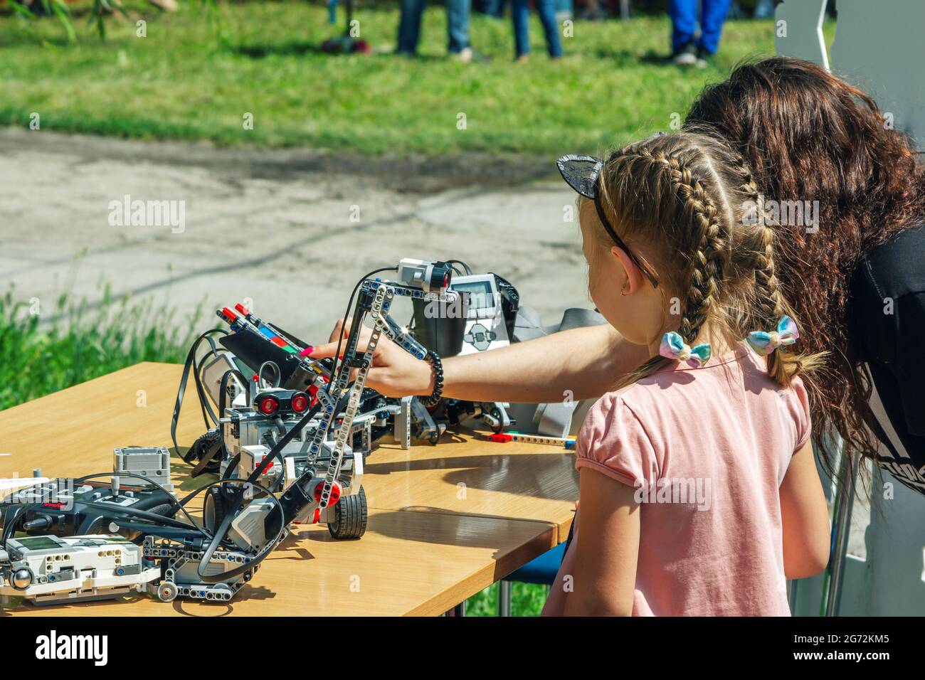Zaporizhia, Ukraine- 19 juin 2021: Festival de la famille de charité: Fille et sa mère explorant des robots à l'extérieur exposition de technologies modernes. Banque D'Images