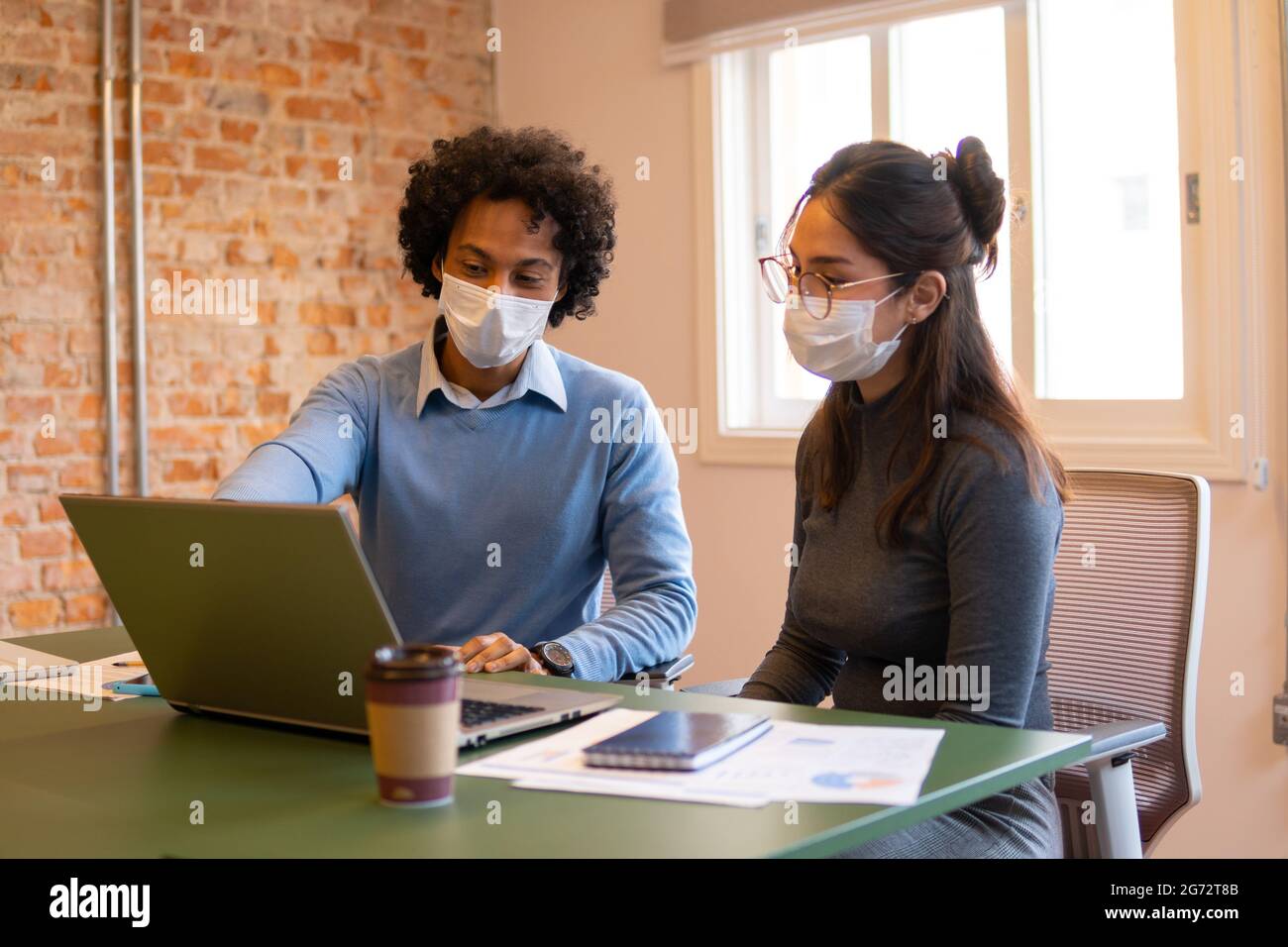 les coéquipiers travaillent en collaboration et discutent lors d'une réunion avec un masque facial Banque D'Images