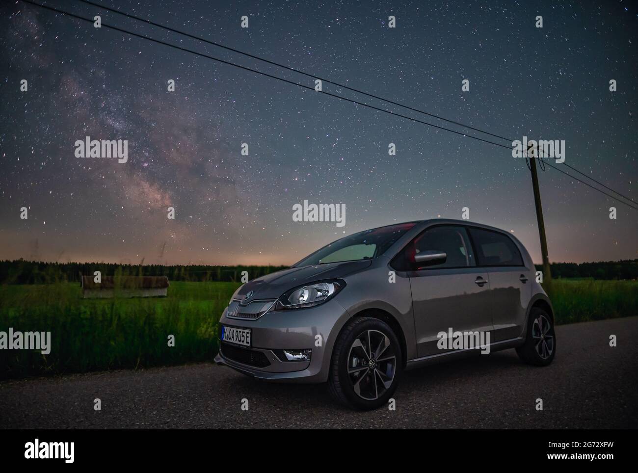 Une nouvelle voiture électrique en plein essor la nuit en face de la milkyway, concept de nouvelles innovations pour sauver notre environnement. Banque D'Images