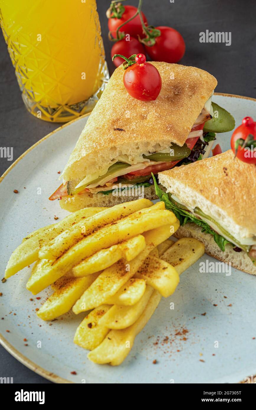 sandwich au jambon, au fromage et à la tomate avec frites et jus d'orange. Banque D'Images