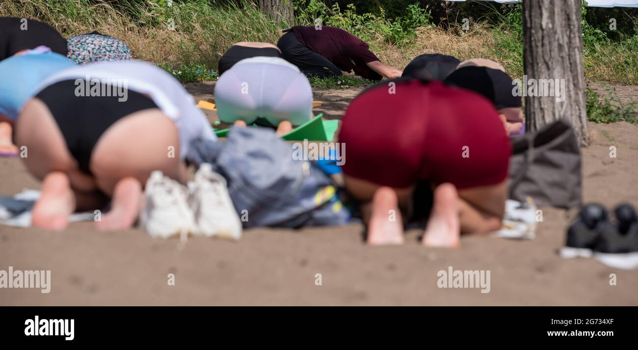 groupe de jeunes femmes faisant du yoga sur la plage real people sain style de vie Banque D'Images