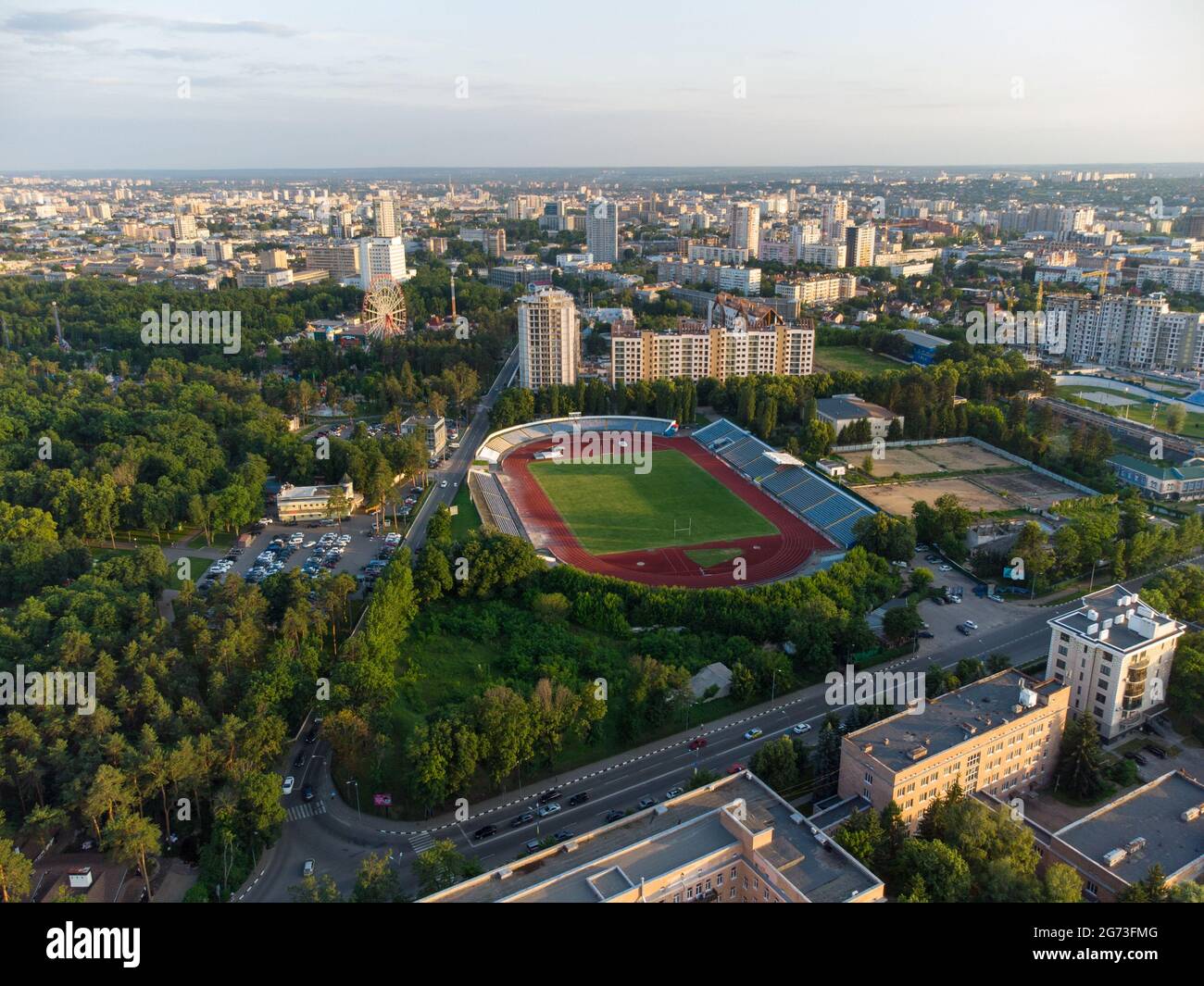 Vue sur le centre-ville de Kharkiv près du parc de Maxim Gorky, stade et bâtiments résidentiels à plusieurs étages avec coucher de soleil pittoresque ciel nuageux en été Banque D'Images