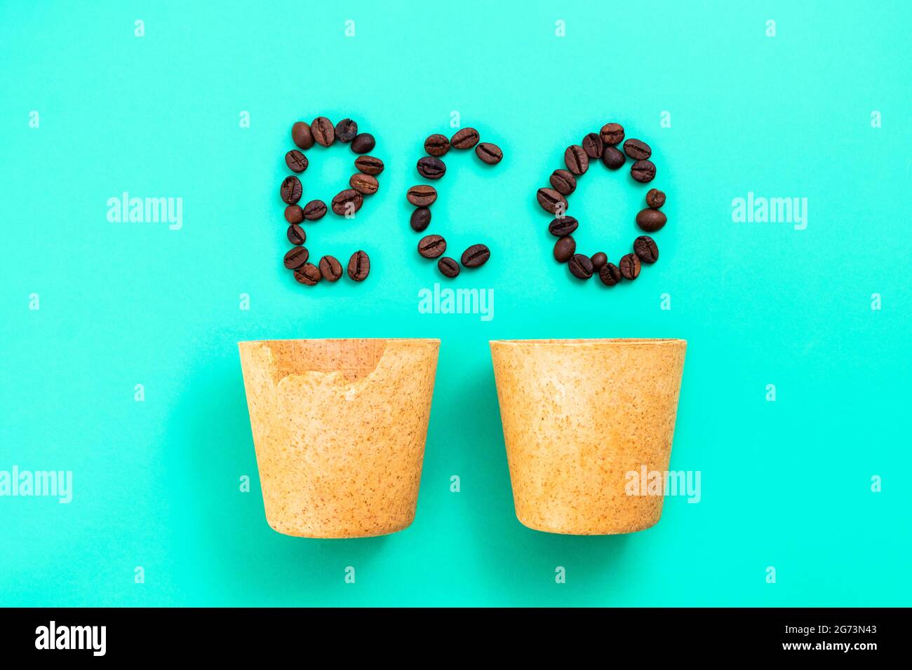Buvez et mangez - tasses à café comestibles avec des mots ECO faits de grains de café sur fond vert, vue du dessus Banque D'Images