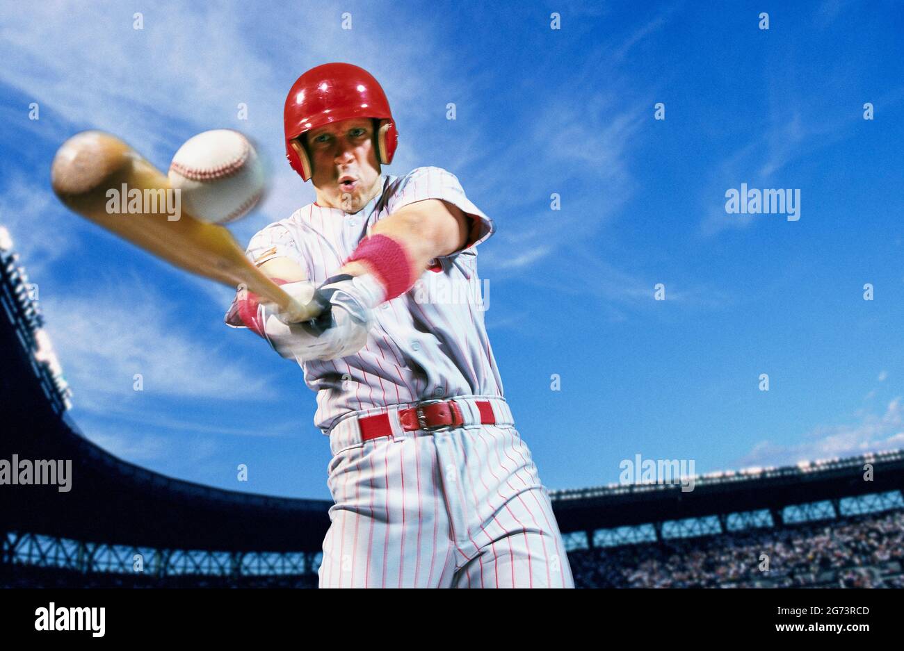Un joueur de baseball professionnel qui se balance et frappe un baseball. Banque D'Images