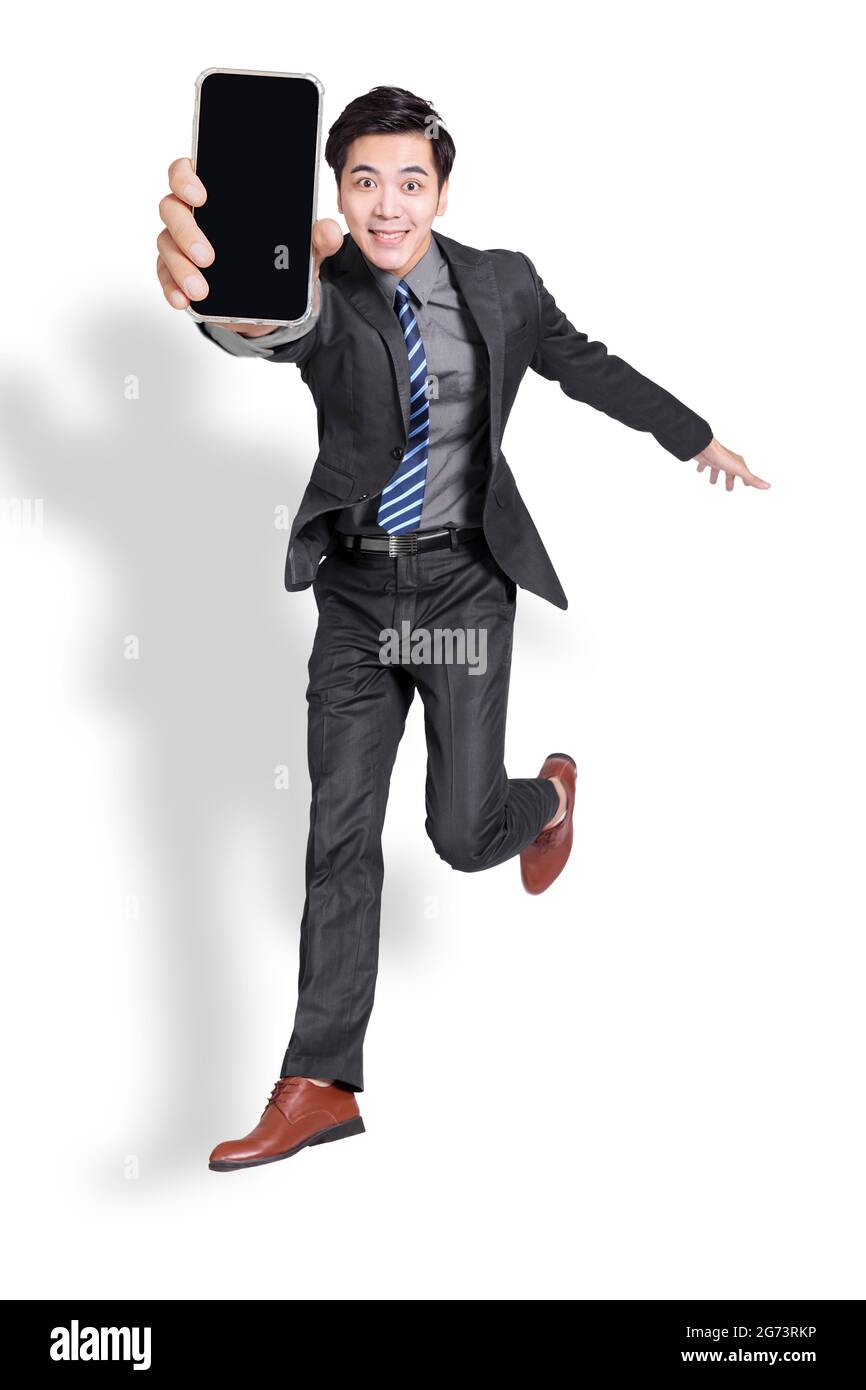 un homme d'affaires enthousiaste qui saute et montre son téléphone portable. Isolé sur fond blanc. Banque D'Images