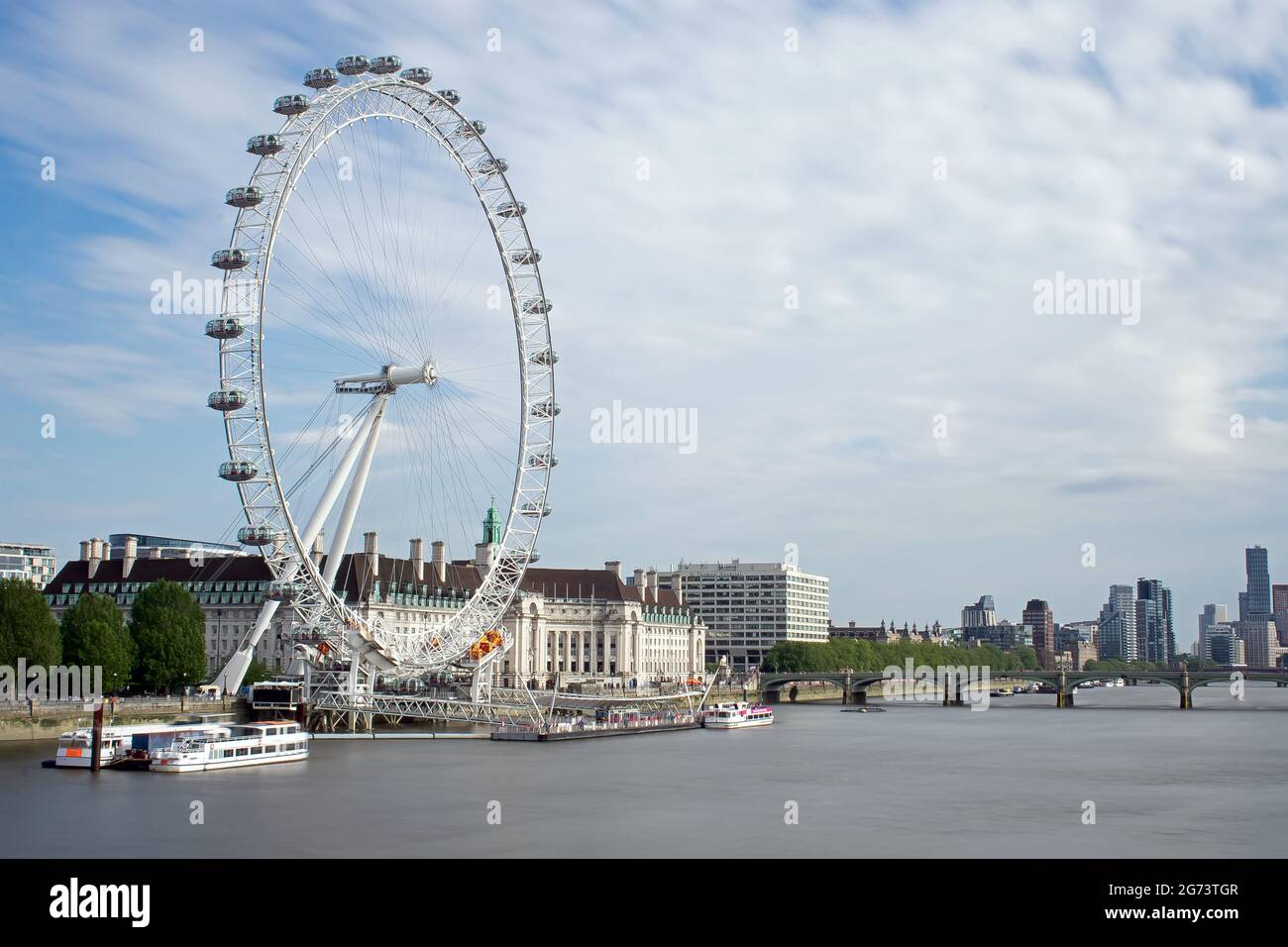 Le London Eye and County Hall dans le soleil de l'après-midi, vu du pont du Jubilé d'or. Le pont de Westminster traverse la Tamise, Londres, Royaume-Uni Banque D'Images