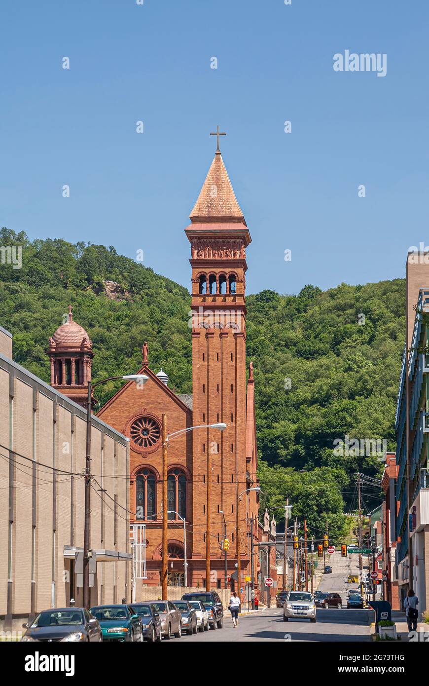 Johnstown, PA, USA - 11 juin 2008: Bâtiment en brique rouge avec 2 tours de la cathédrale Saint John Gualbert avec Locust Street menant vers la ceinture de verdure Banque D'Images