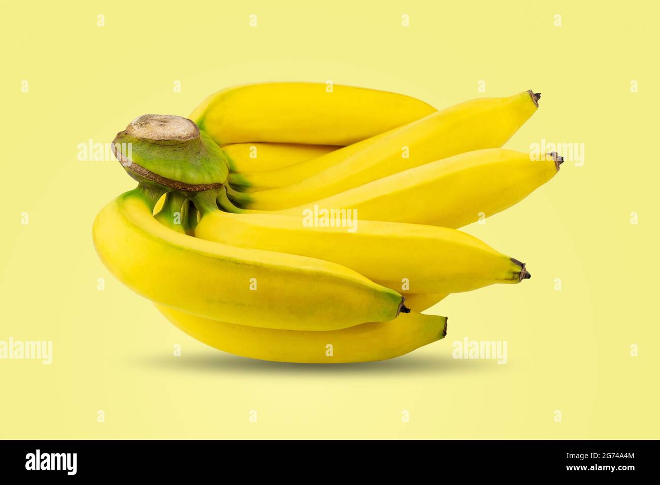 Groupe de bananes mûres pelées de couleur jaune sur la même branche isolée sur fond jaune pastel. Banque D'Images Groupe de bananes mûres pelées de couleur jaune sur la même branche isolée sur fond jaune pastel. Banque D'Images