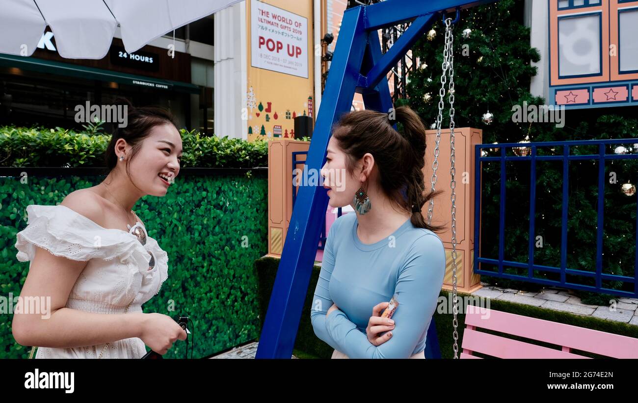 Deux modèles de filles orientales posé par des décorations de Noël sur la route de Sukhumvit à Bangkok en Thaïlande Banque D'Images