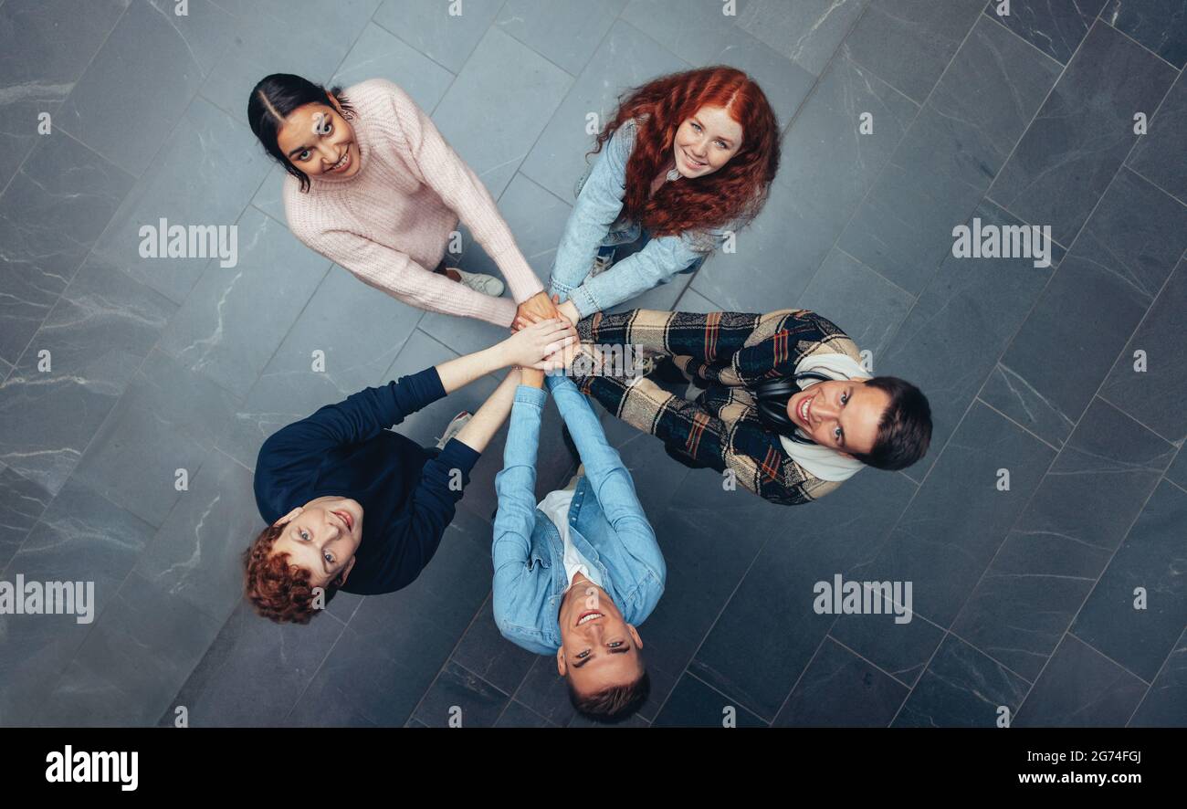 Vue de dessus d'un jeune debout et de mettre ses mains ensemble. Divers élèves avec les mains empilées. Banque D'Images