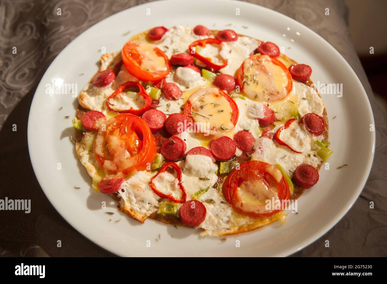 Œufs brouillés avec saucisses, tomates, poivre et verdure dans une poêle à frire Banque D'Images