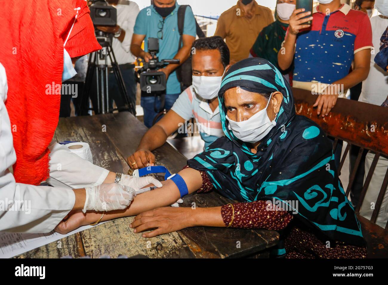 Un médecin prélève des échantillons de sang auprès des parents des victimes de l'incendie de l'usine de Narayanganj Hashem Foods Ltd pour des tests d'ADN à Dhaka M. Banque D'Images