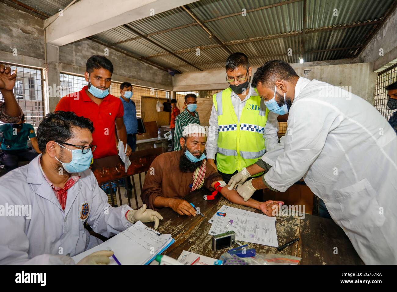 Un médecin prélève des échantillons de sang auprès des parents des victimes de l'incendie de l'usine de Narayanganj Hashem Foods Ltd pour des tests d'ADN à Dhaka M. Banque D'Images