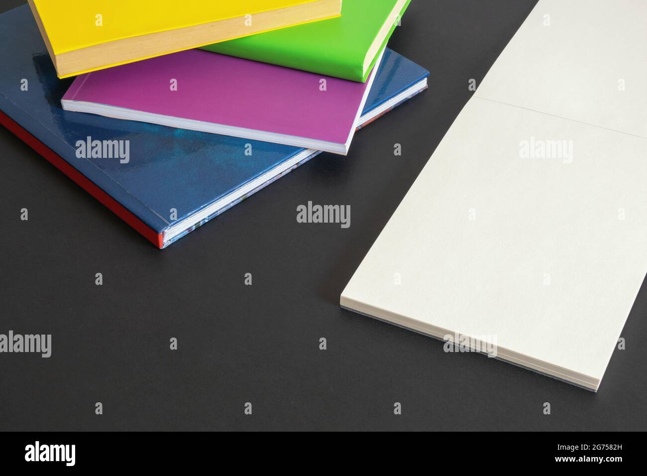 Concept scolaire. Livres colorés et croquis ouverts sur fond sombre. Espace libre pour le texte Banque D'Images