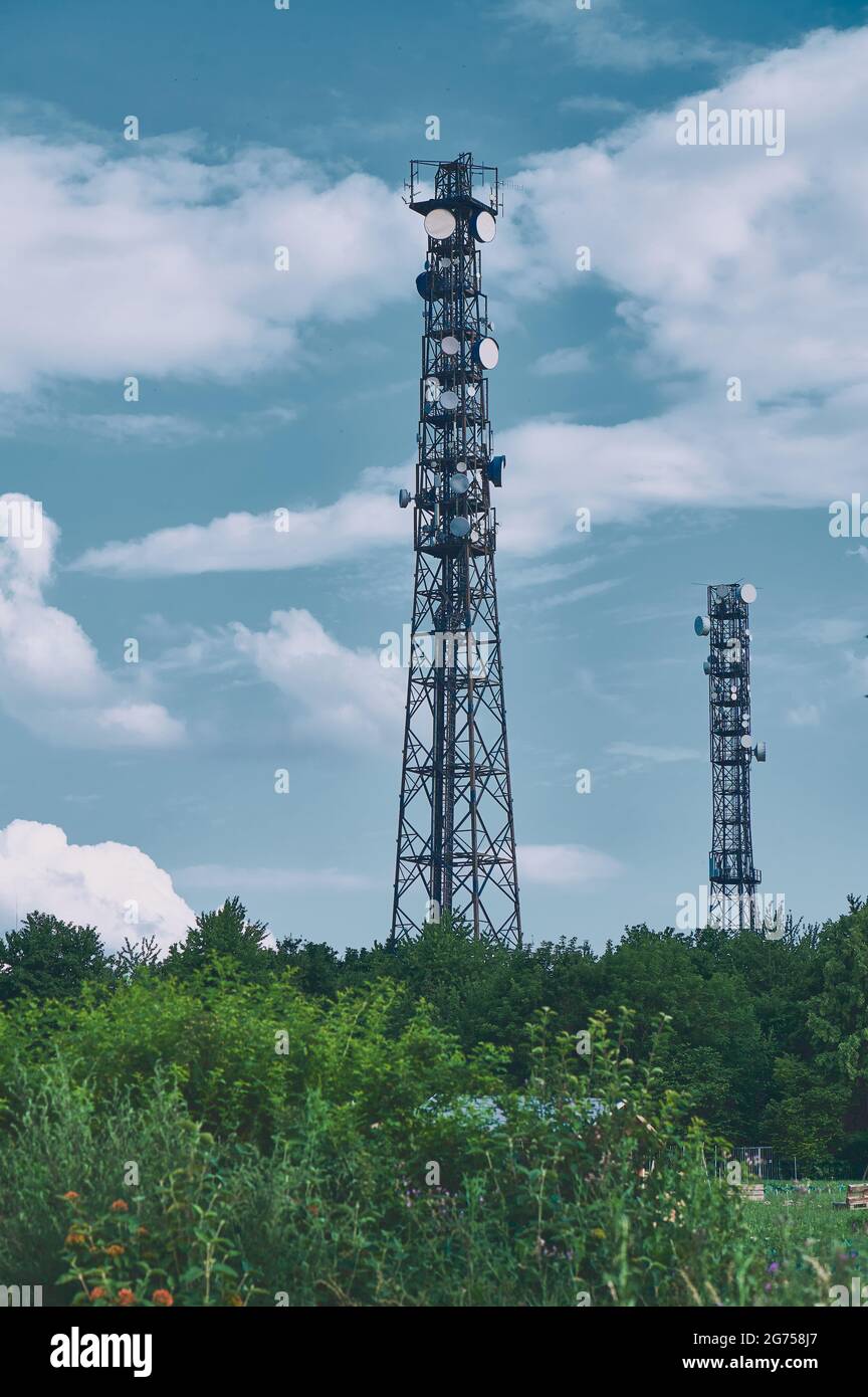 mâts de télécommunication contre ciel bleu nuageux Banque D'Images