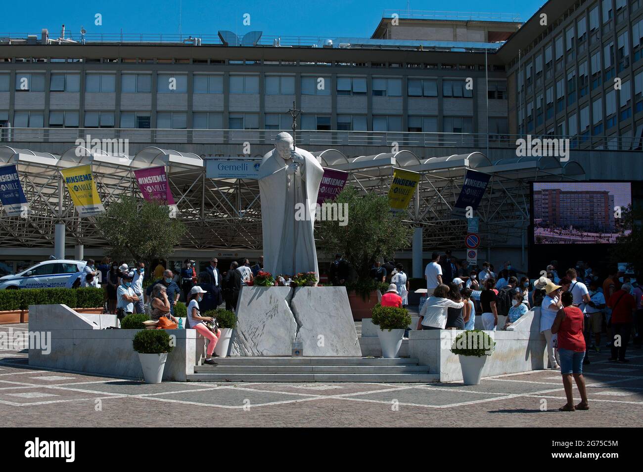 Rome, Italie. 11 juillet 2021. 11 juillet 2021 : les gens se tiennent autour d'une statue de Jean-Paul II à l'extérieur de l'hôpital Gemelli, d'où le Pape François est censé diriger la prière Angelus, comme il se rétablit après la chirurgie programmée son côlon, à Rome crédit: Agence de photo indépendante/Alamy Live News Banque D'Images