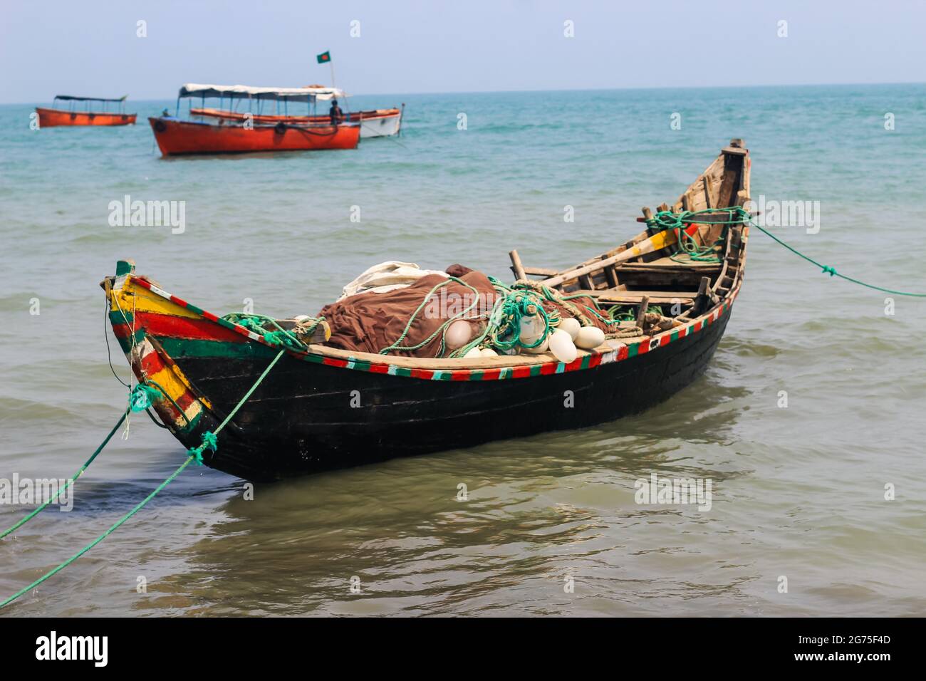 Bateau de pêche traditionnel bangladais sur l'île Saint-Martin. Pêcheur préparant le bateau pour la voile dans l'océan. Bateaux de pêche colorés. Banque D'Images