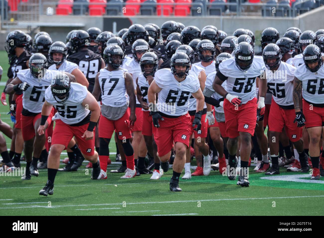 Ottawa, Canada. 11 juillet 2021. L'offensif Nolan McMillan (66) dirige les joueurs en train d'effectuer des exercices alors que les Red BACKS d'Ottawa de la Ligue canadienne de football (LCF) ouvrent leur camp d'entraînement à la TD place alors qu'ils se mettent à ouvrir la saison 2021. Après avoir annulé toute la saison dernière en raison de la pandémie, la LCF est prévue pour jouer cette saison en vertu d'un protocole approuvé. Credit: Meanderingemu/Alamy Live News Banque D'Images