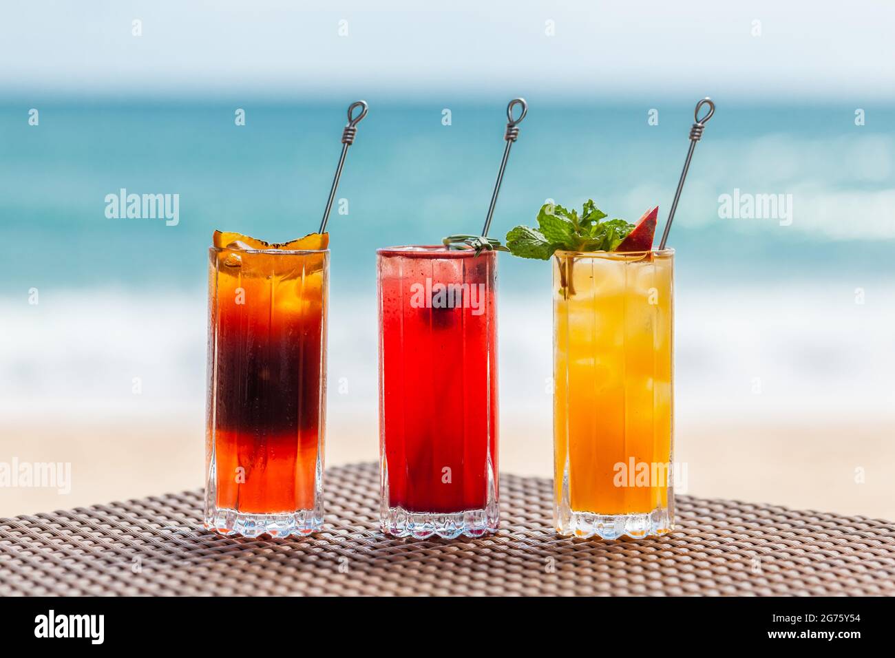 Ensemble de cocktails de fruits rafraîchissants sur la table de la plage près de la mer Turquoise Banque D'Images