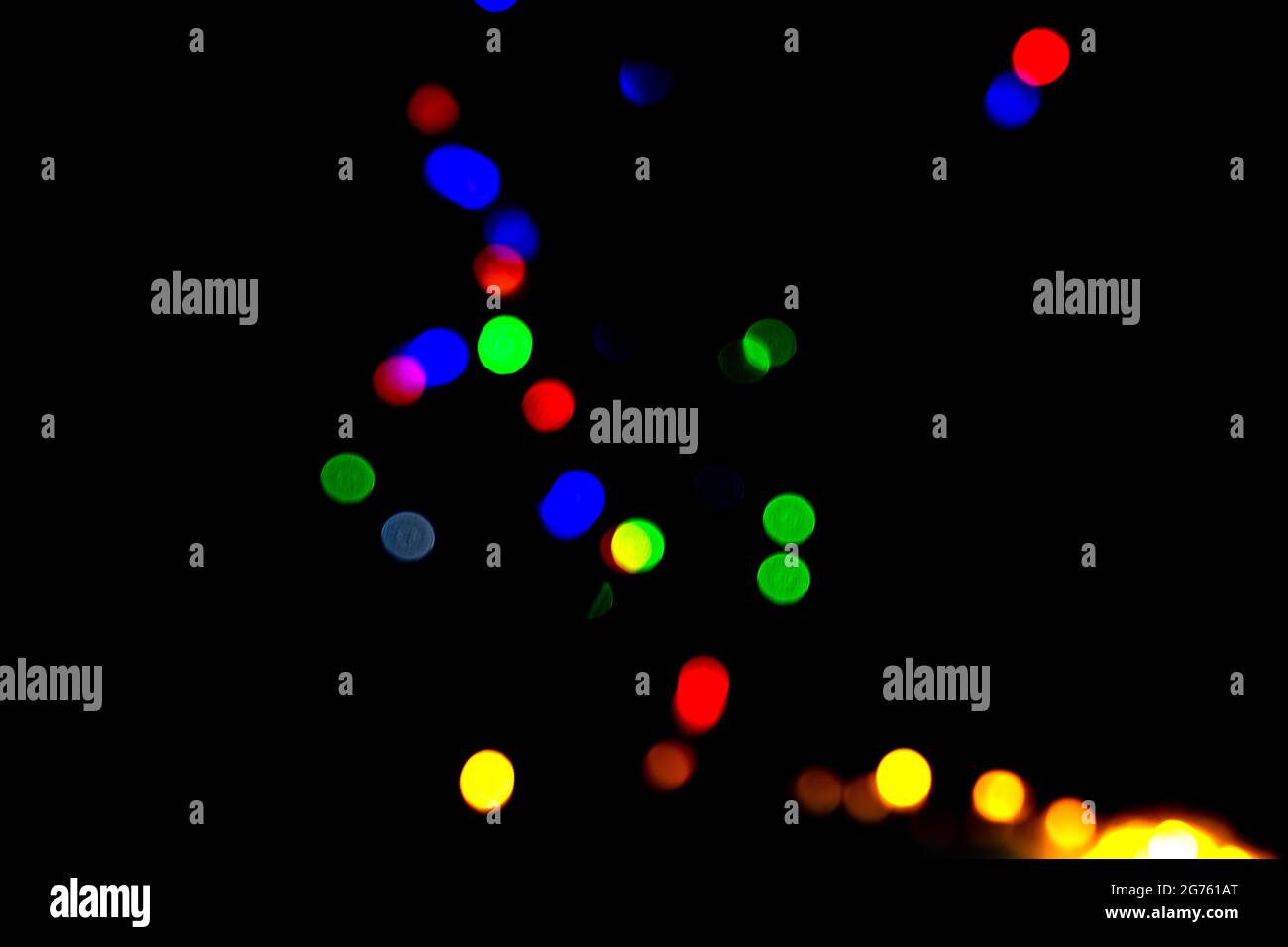 des lumières de bokeh colorées étincelantes sur fond noir. Banque D'Images