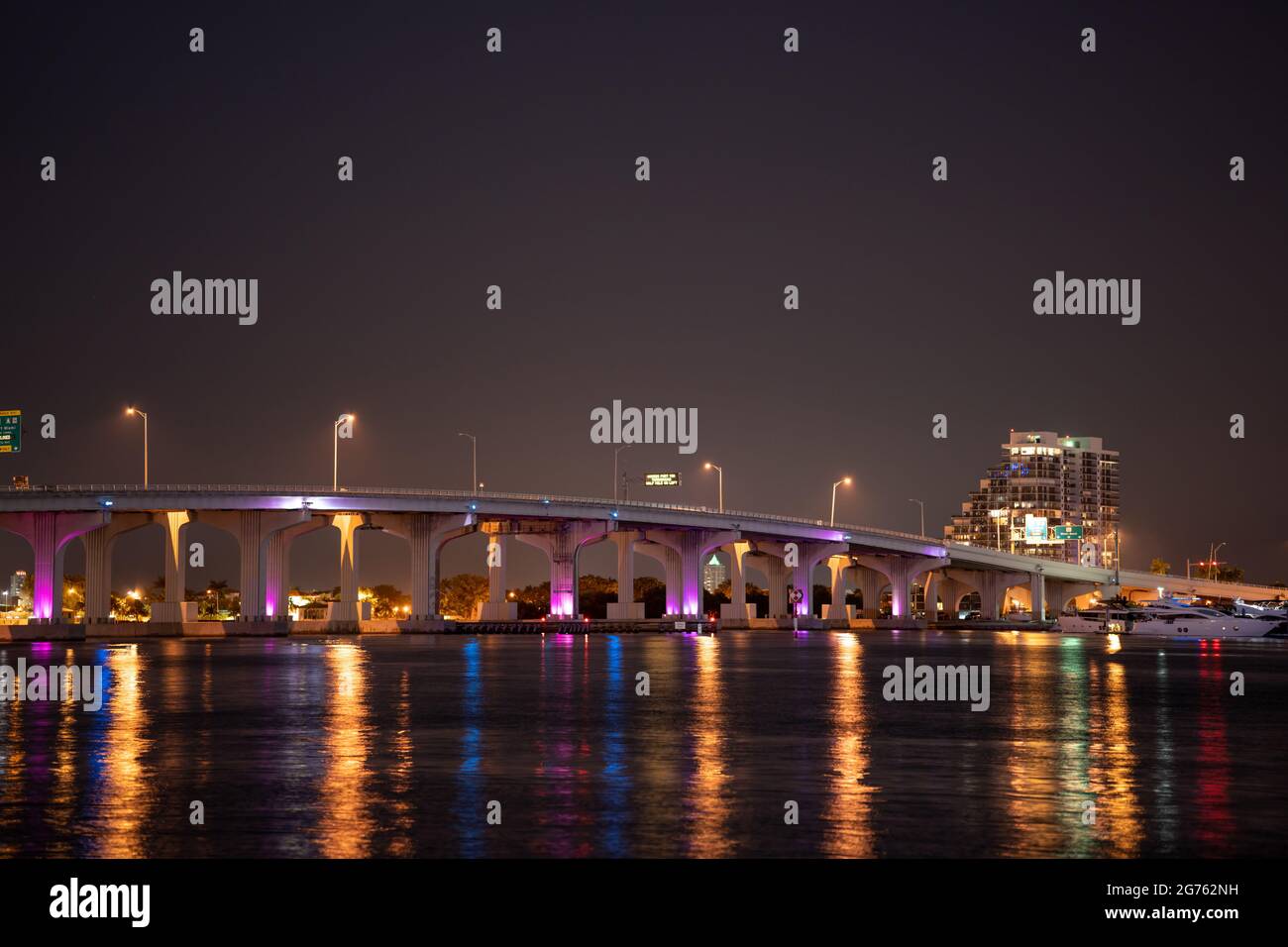 MacArthur Causeway Miami éclairé en bleu fluo la nuit Banque D'Images